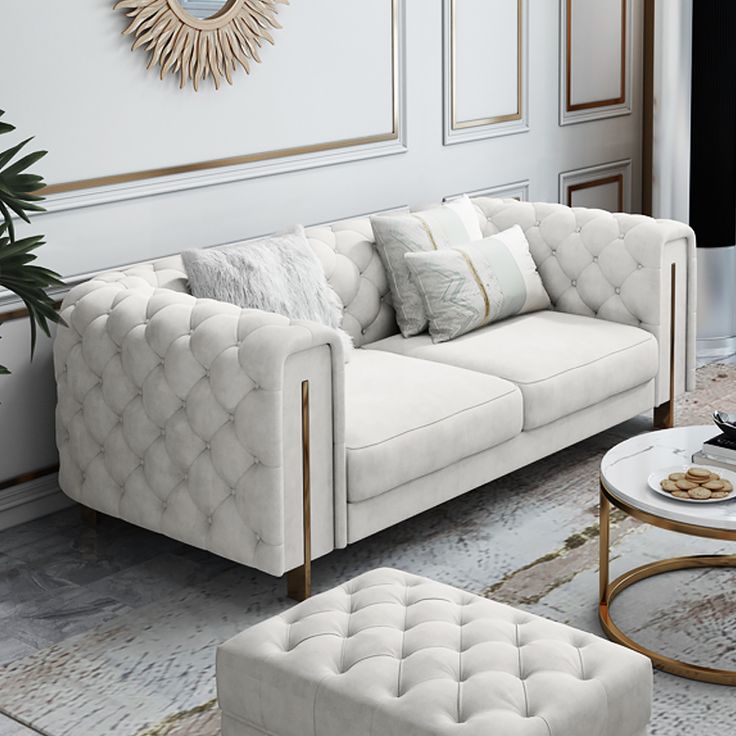 an elegant living room with white furniture and gold accents