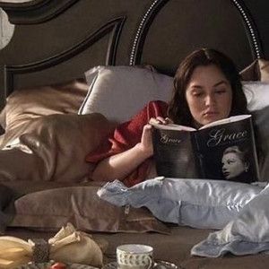 a woman laying in bed reading a book