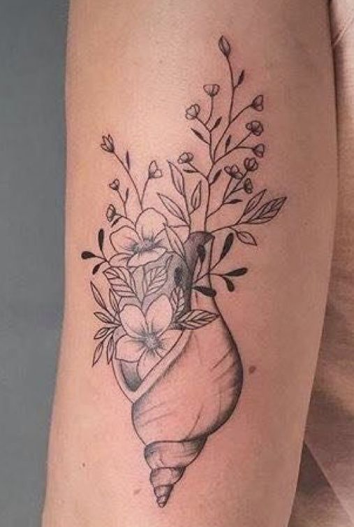 a woman's arm with flowers in a vase tattoo on the left side of her body