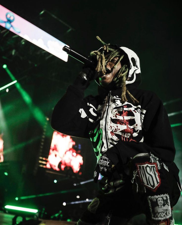 a man with dreadlocks holding a microphone in his hand