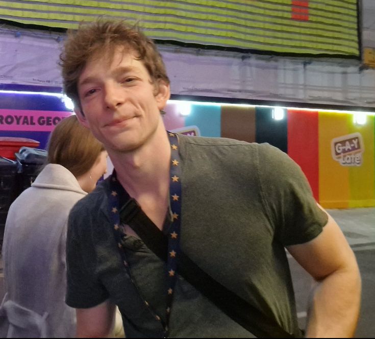 a man standing in front of a store with his hands on his hips and looking at the camera