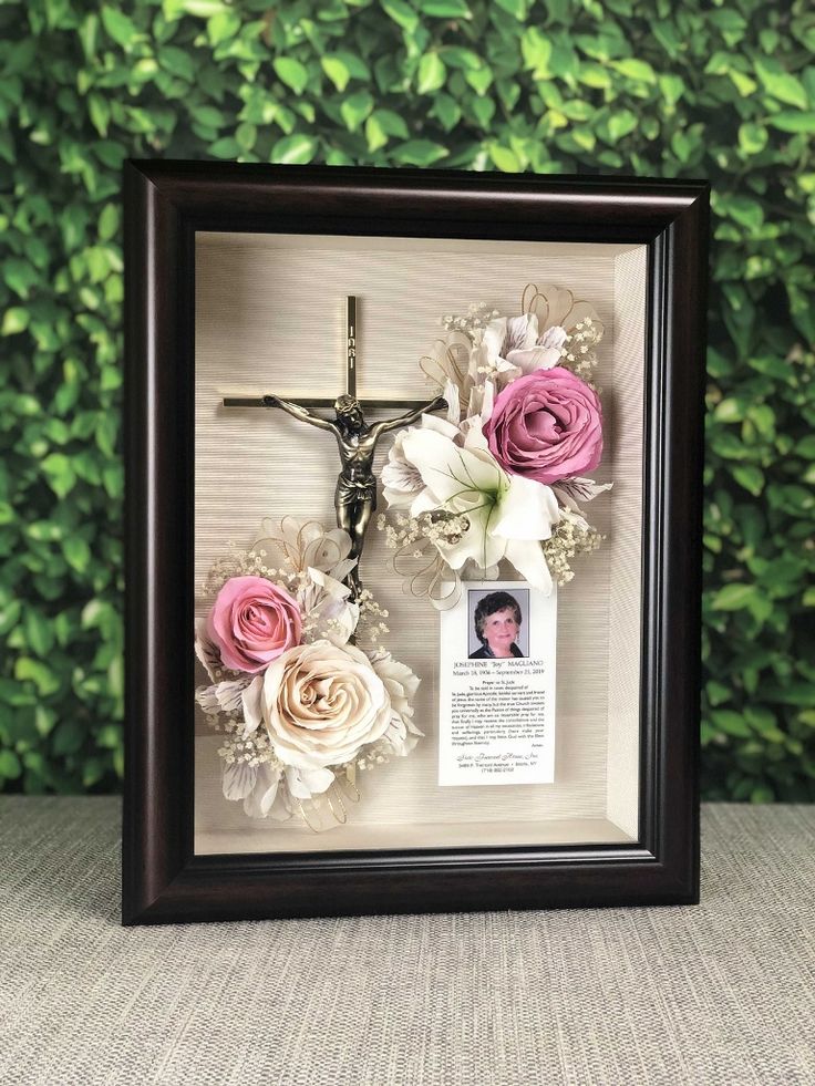 a cross and flowers in a shadow box