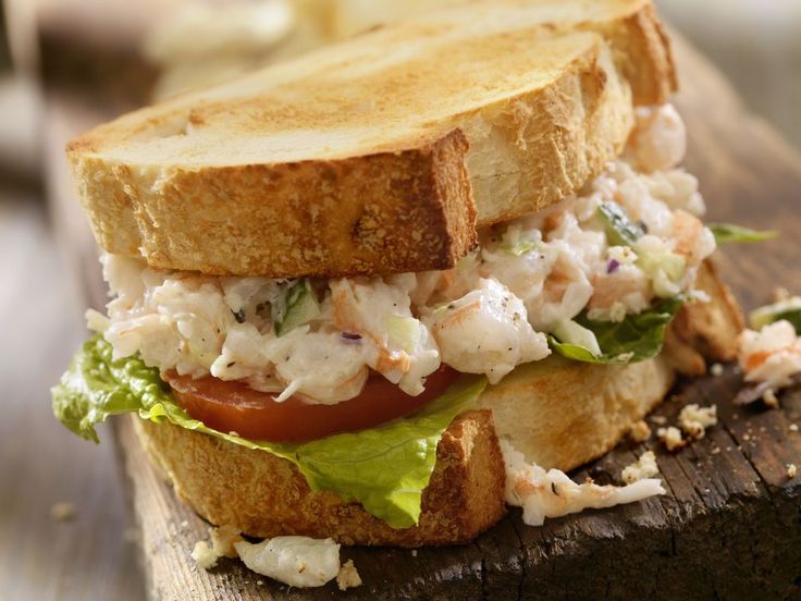 a sandwich with chicken salad and lettuce on toasted bread