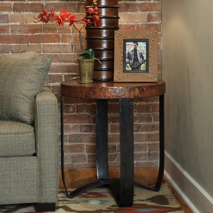 a living room with a couch, chair and table in front of a brick wall