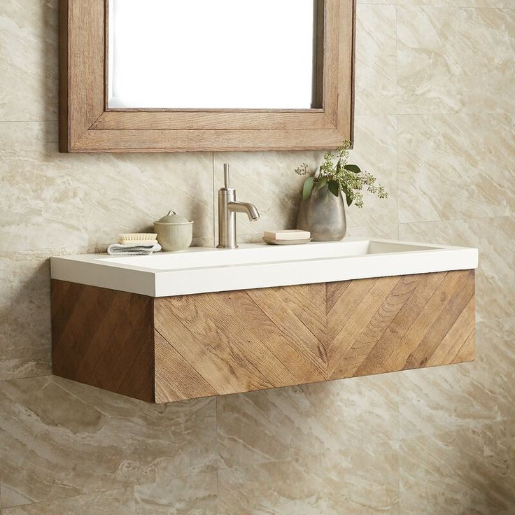 a bathroom sink sitting under a mirror next to a wall mounted faucet with a wooden frame