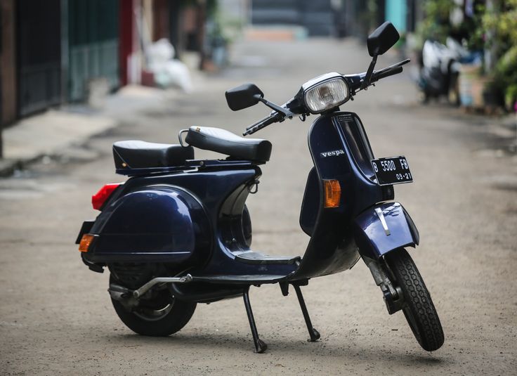 a blue scooter parked on the side of a road