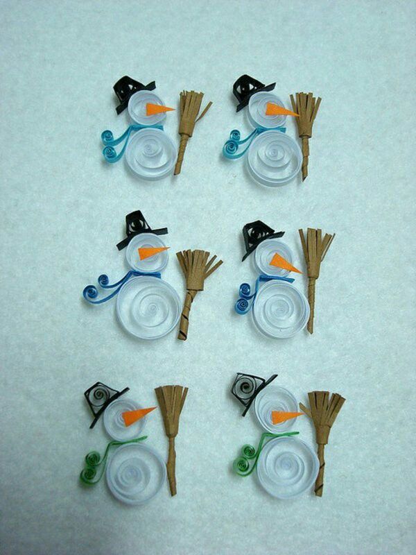 six snowmen made out of plastic plates and brooms on a white tablecloth