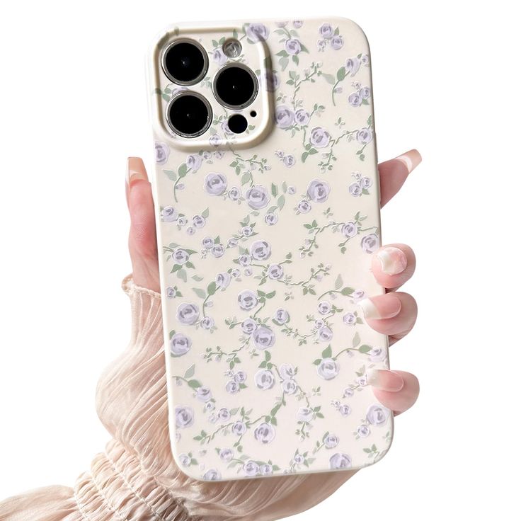 a woman holding up an iphone case with flowers on the front and back cover in her hand