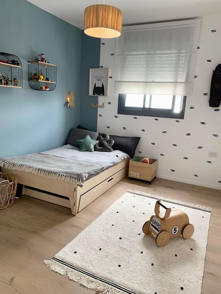 a child's bedroom with blue walls and white carpeted flooring is shown