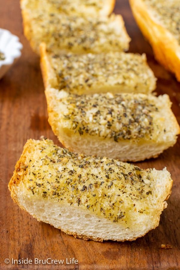 slices of garlic bread on a wooden cutting board