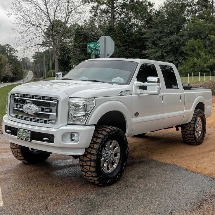 a large white truck parked on top of a dirt road