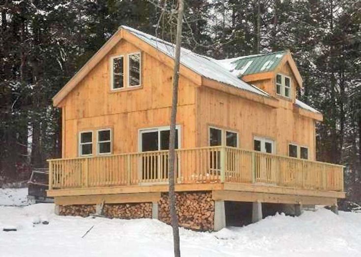 a wooden cabin in the woods with snow on the ground