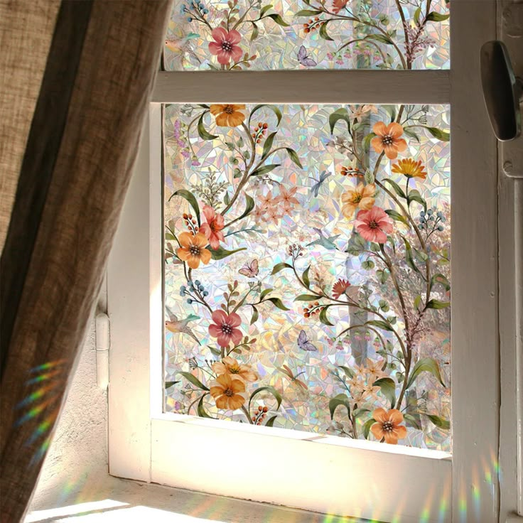 the sun shines brightly through an open window with flowers painted on it in front of a curtain