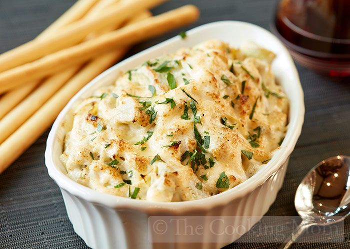 a white dish filled with food next to some sticks