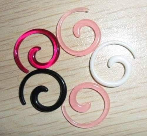 three pairs of pink, black and white spirals on a wooden table with wood grained surface