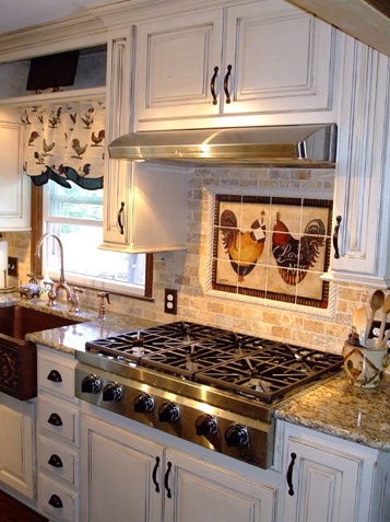 a kitchen with white cabinets and marble counter tops, an oven hood over the stove