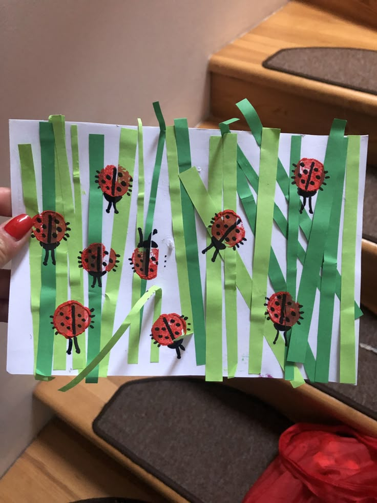 ladybugs on green strips of paper cut out to look like grass