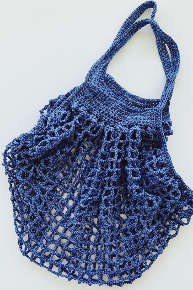 a blue crocheted bag sitting on top of a white table