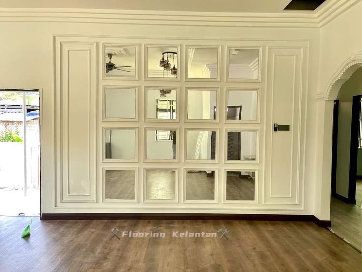 an empty room with white walls and wood flooring is shown in the foreground