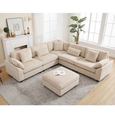 a living room with a sectional couch and ottoman