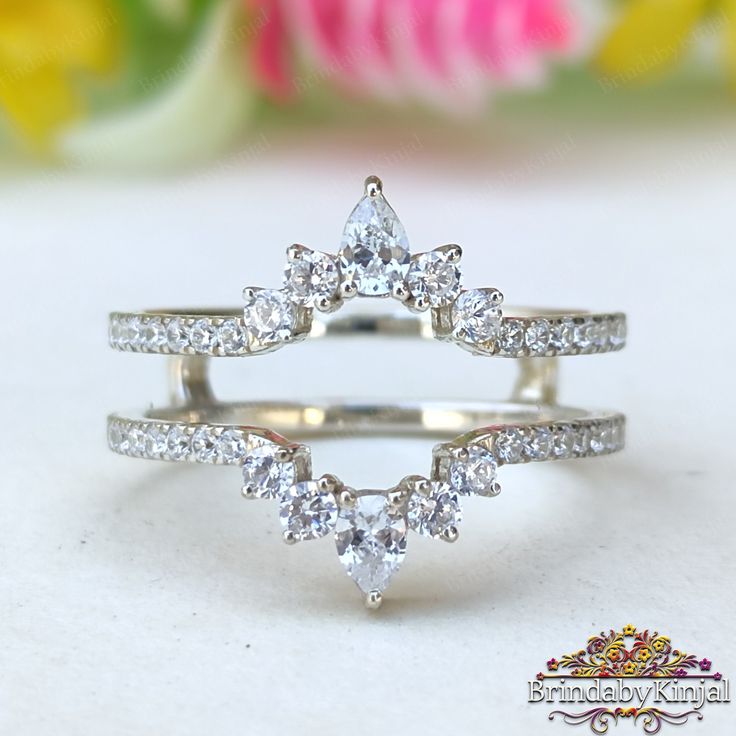 three pieces of white gold ring with diamonds on top and bottom, set against a floral background