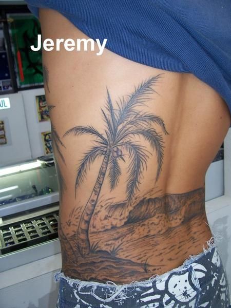 a person with a palm tree tattoo on their back is standing in front of a refrigerator