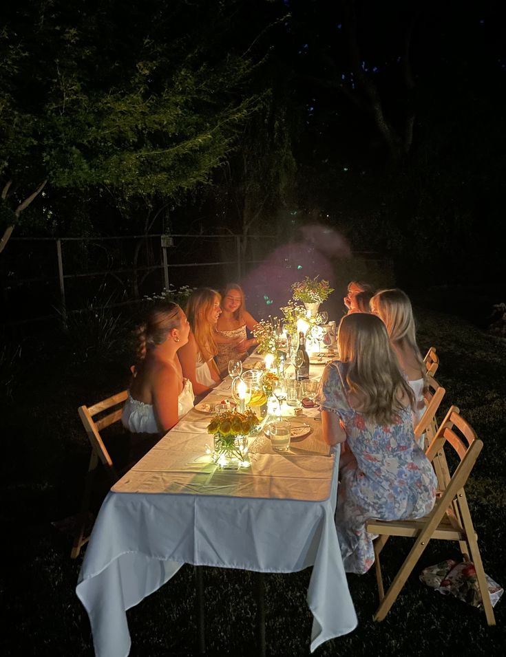 a group of people sitting around a table at night