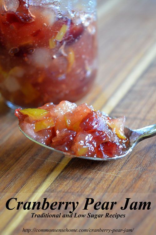 cranberry pear jam in a spoon on top of a wooden table with another spoon