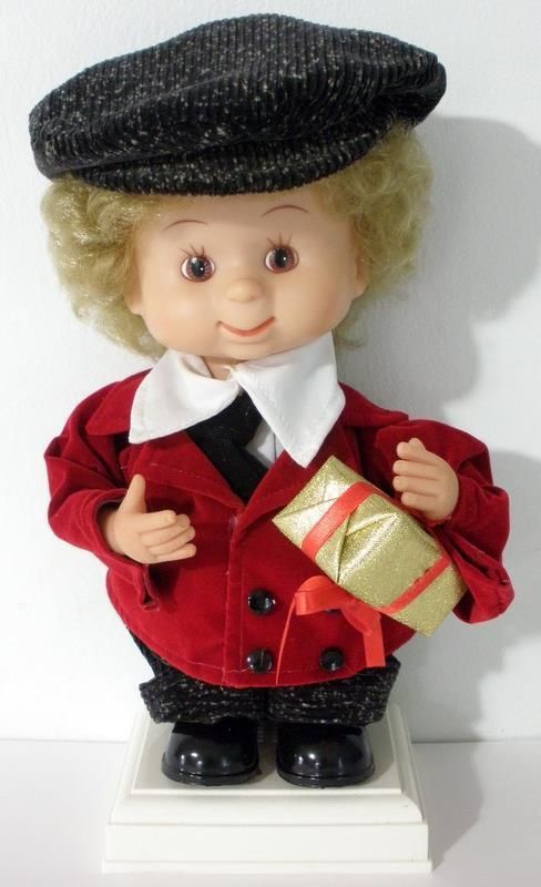 a small doll is dressed in red and black with a hat on it's head