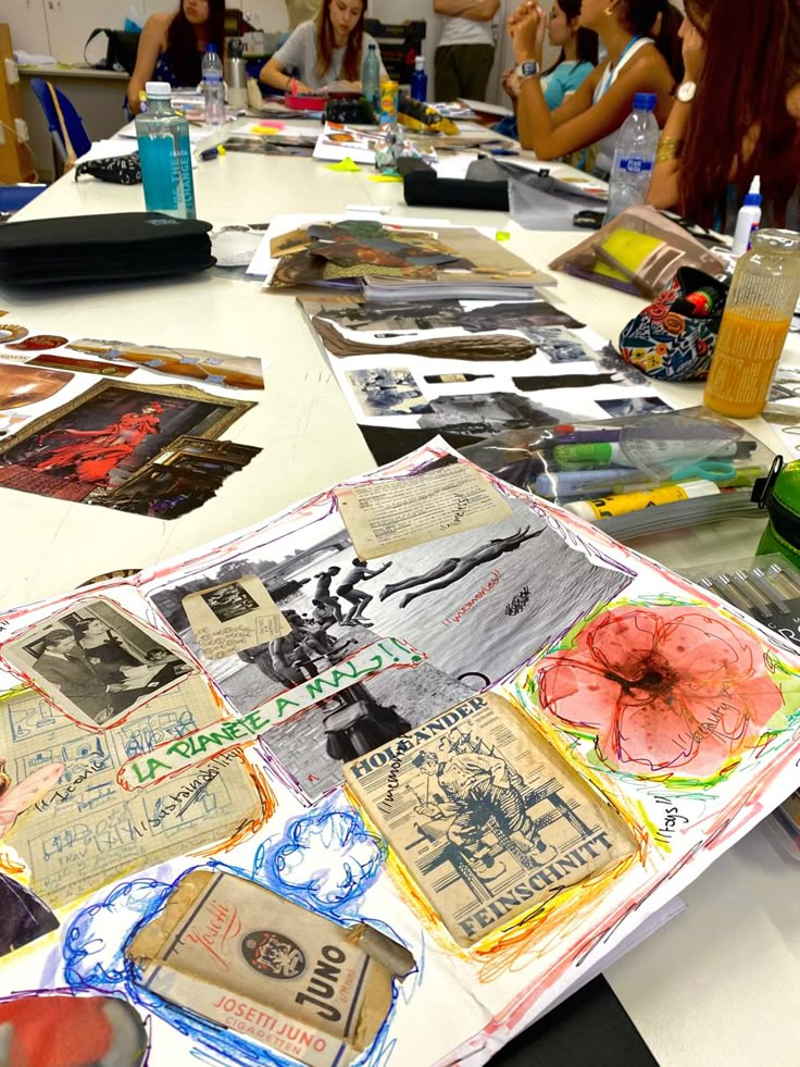 a group of people sitting around a table covered in pictures and papers on top of it