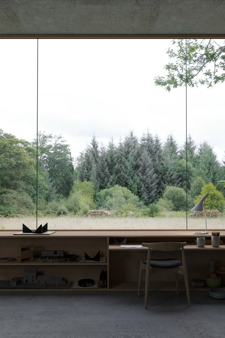 a room with large glass windows overlooking trees and animals in the distance on the floor