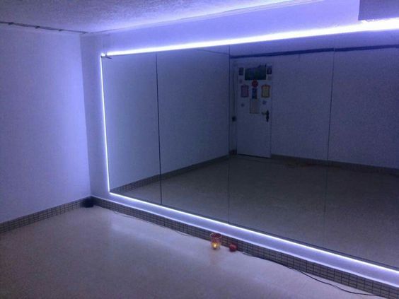 an empty room with a mirror and lights