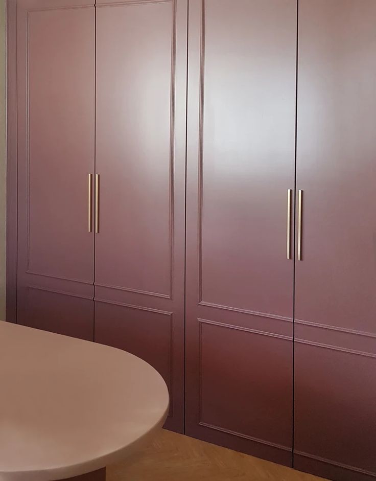 a white table and some purple cabinets in a room