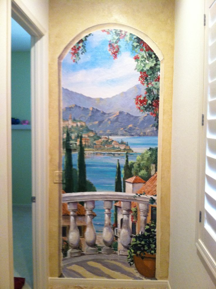 an entry way with a painted mural on the wall and doors leading to another room