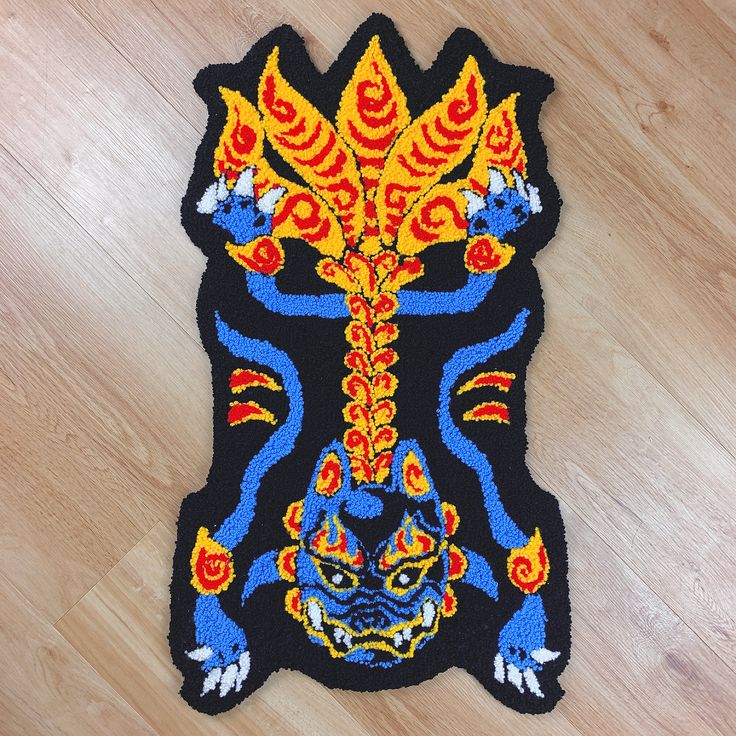 a rug with an image of a dragon on it's back and yellow flames coming out of its mouth