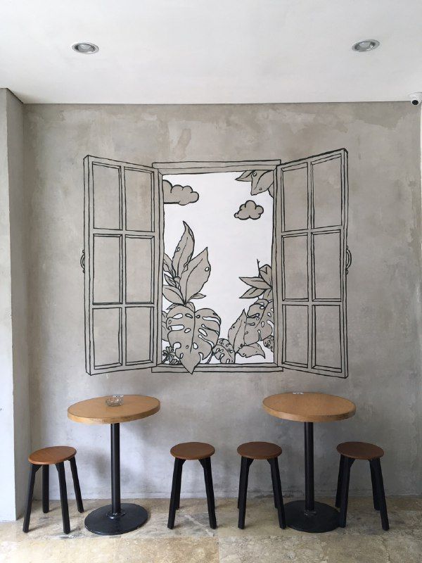 three stools in front of an open window with plants drawn on the wall behind them