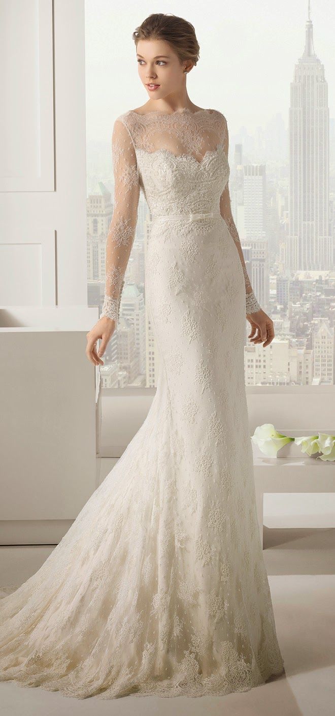 a woman in a wedding dress standing by a window with her hands on her hips