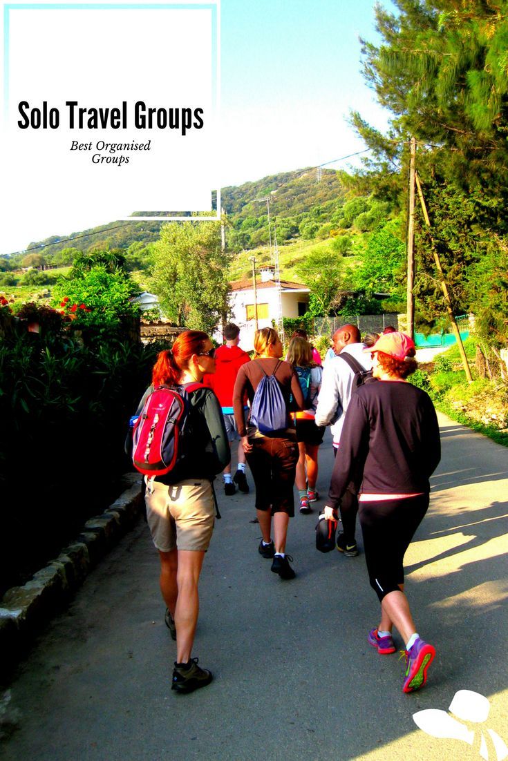 group of people walking down the road with backpacks