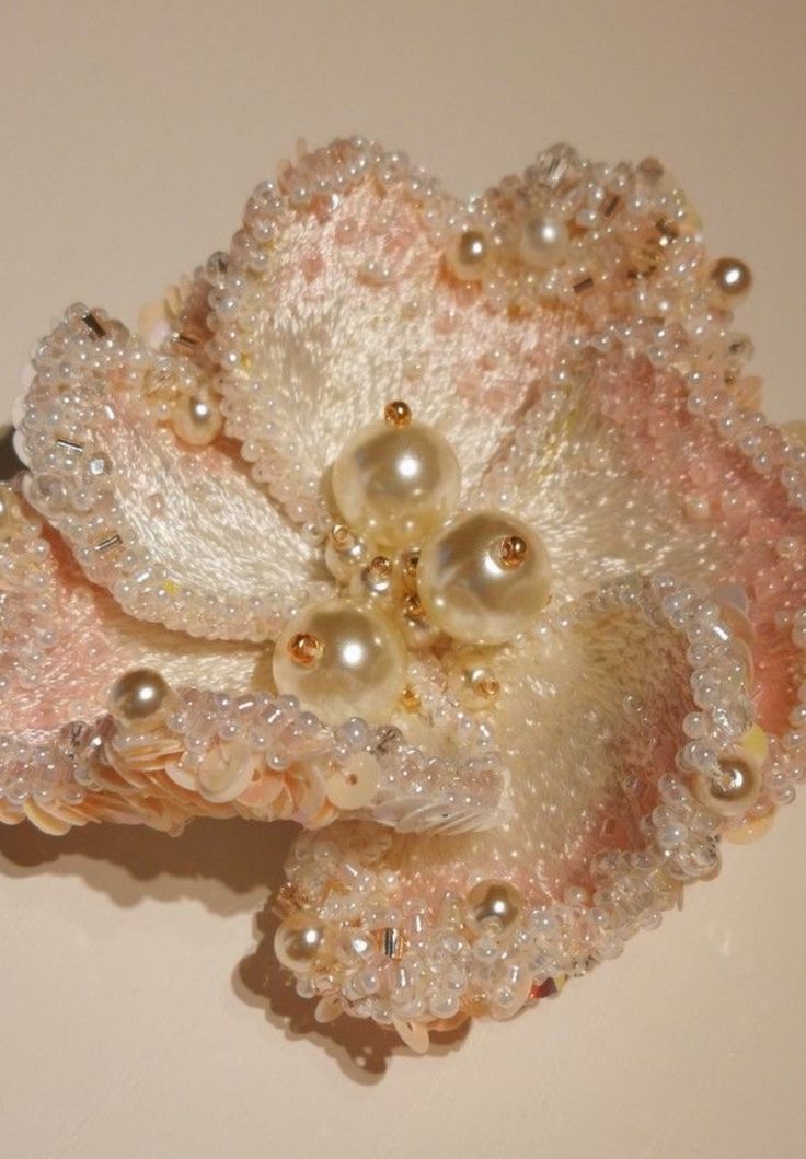 a close up of a flower with pearls on it