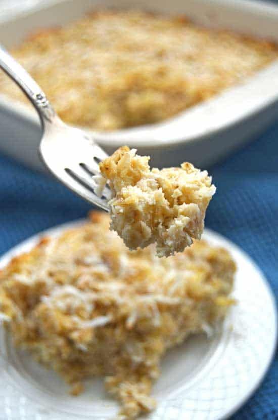 a white plate topped with food next to a casserole dish filled with cheese