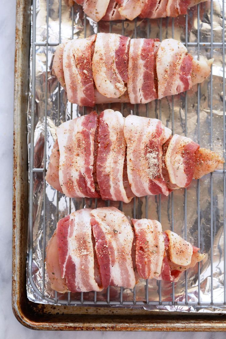 bacon wrapped chicken on a baking sheet ready to go into the oven for dinner or appetizing