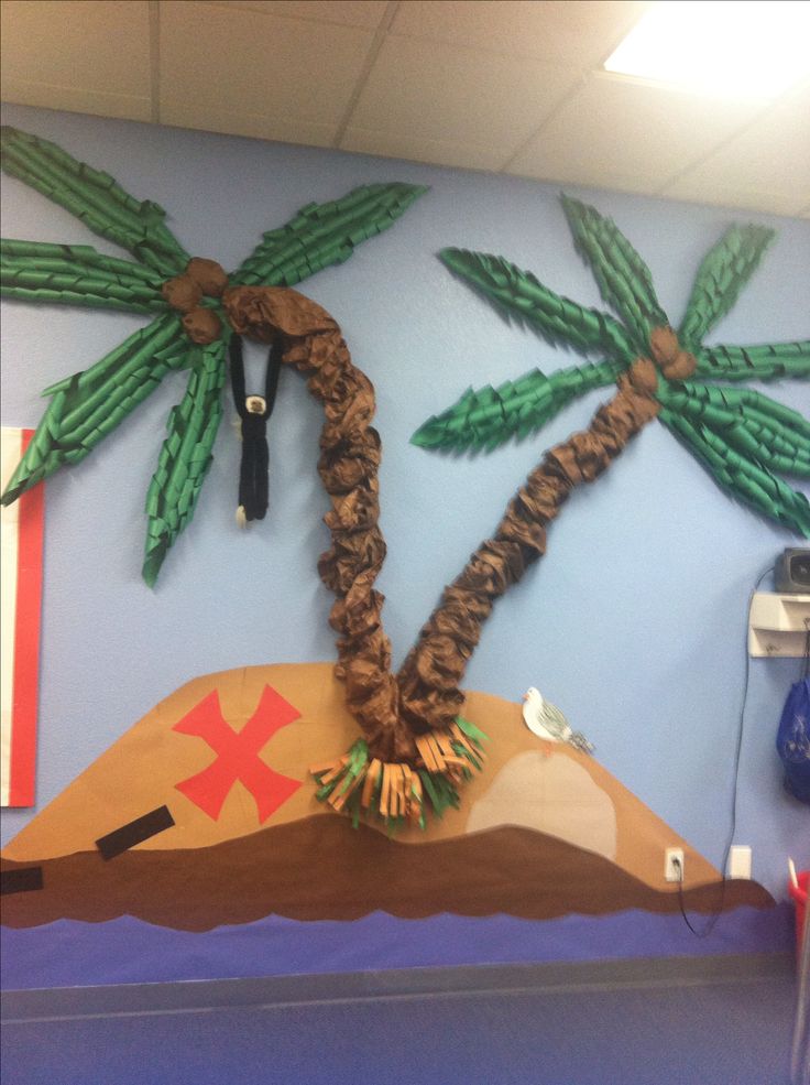 a classroom wall decorated with palm trees and pirate ship paper mache on the bottom