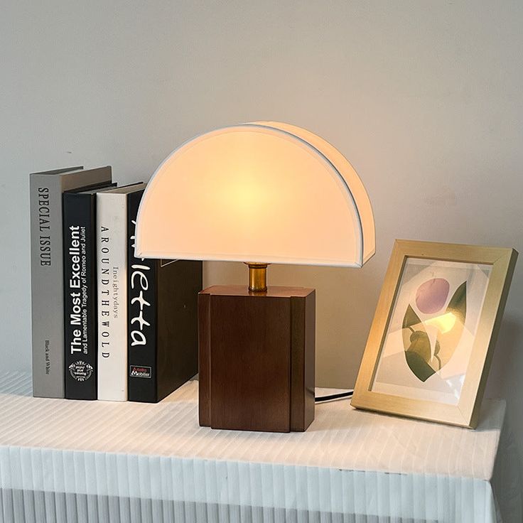 a lamp sitting on top of a table next to books