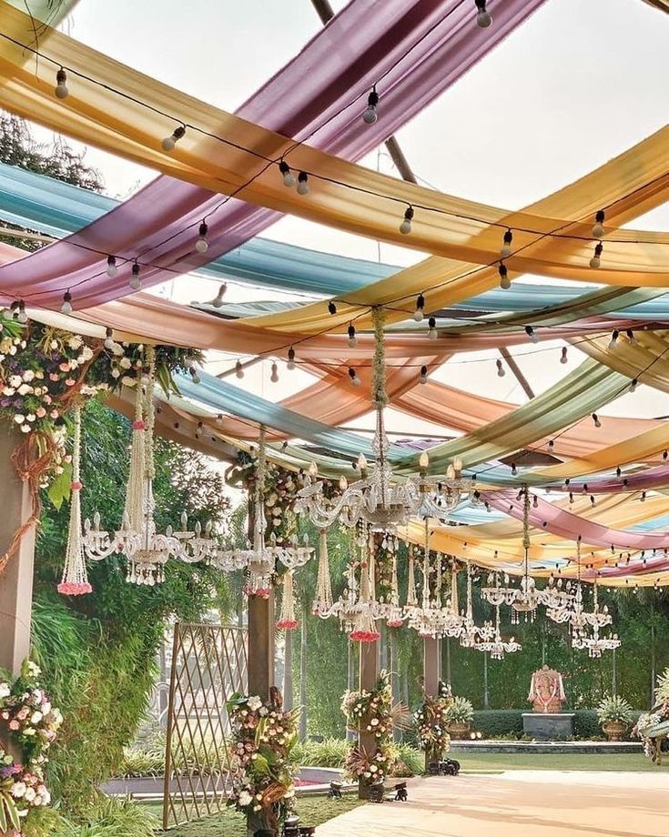 an outdoor wedding venue decorated with flowers and chandeliers