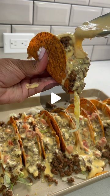 a person is dipping cheese on top of some tortilla shells with meat and vegetables