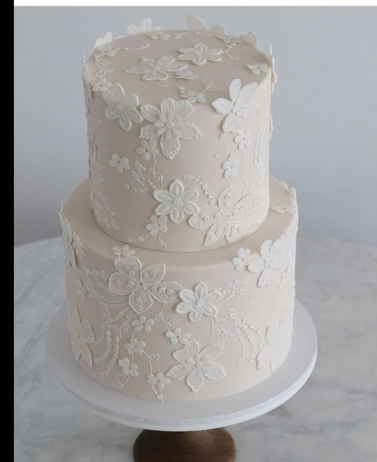 a three tiered cake with white flowers on it