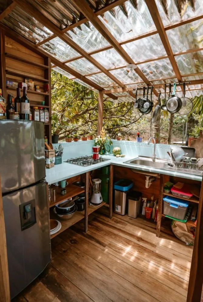 an outdoor kitchen with wooden floors and walls