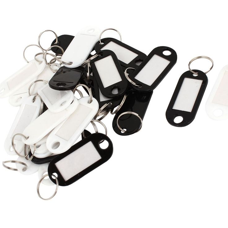 a bunch of white and black key chains with tags attached to them on a white background