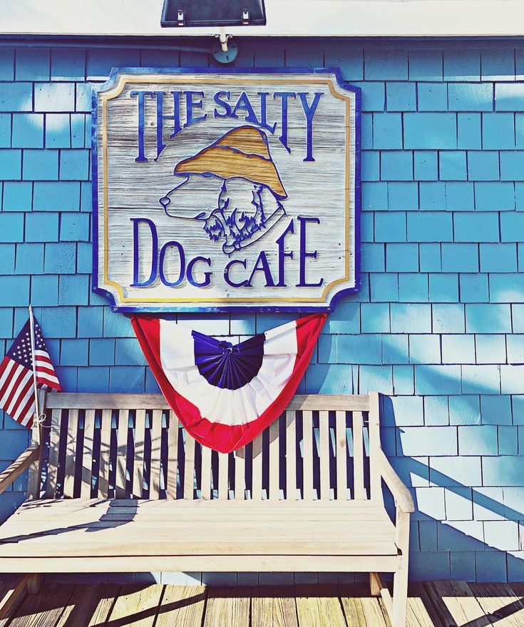 a sign for the salty dog cafe with an american flag on it's back