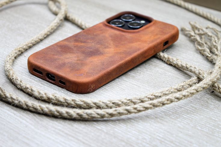 a brown leather case sitting on top of a white table next to a roped cord